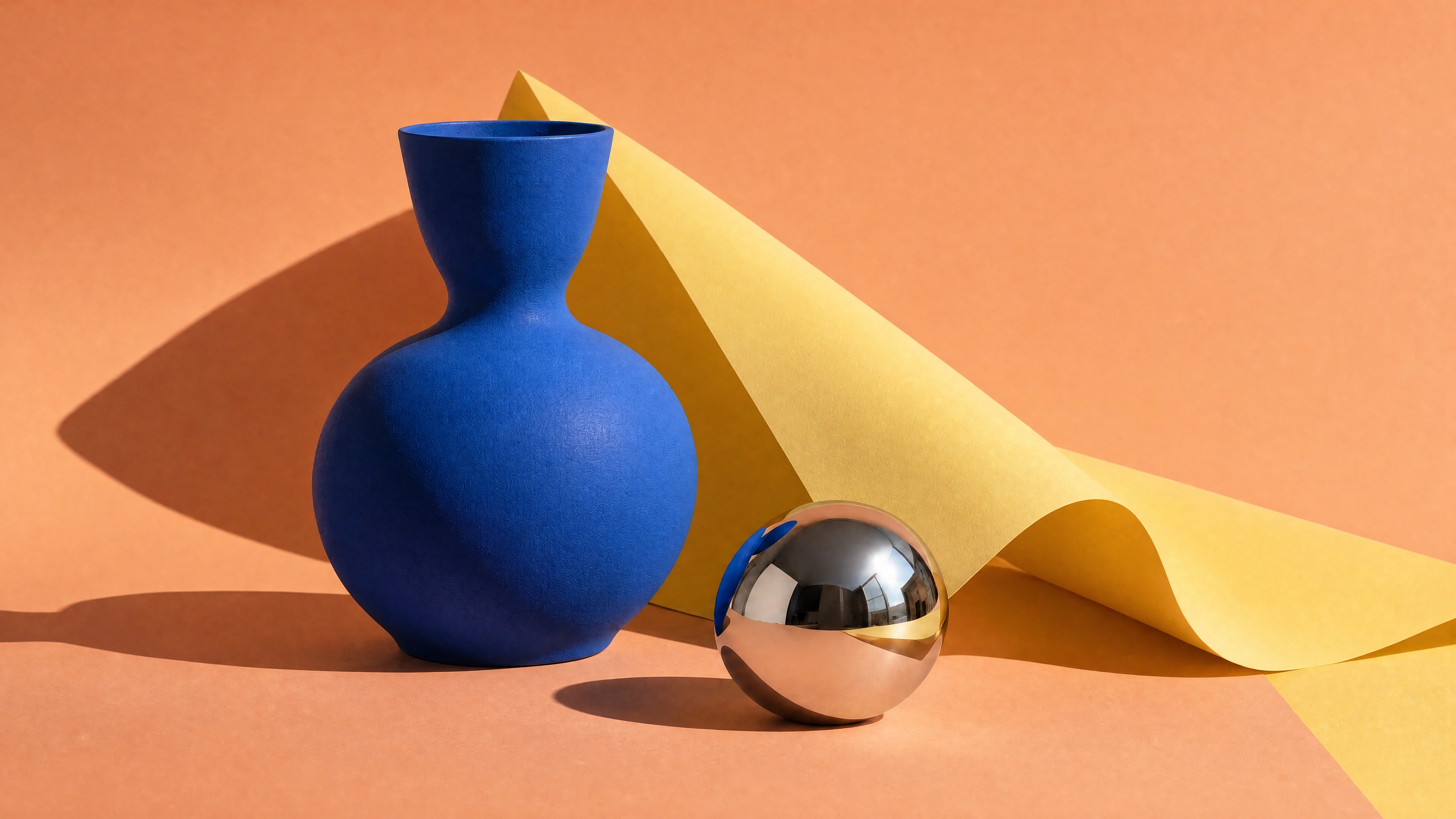Cobalt ceramic vase, chrome sphere and yellow paper